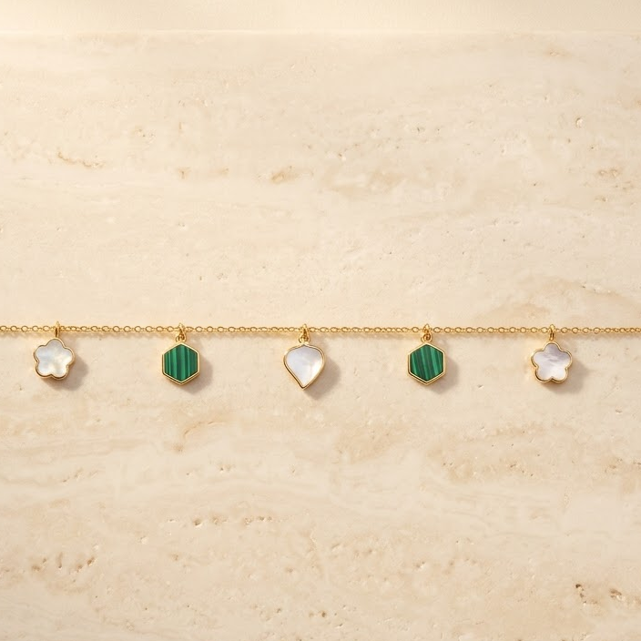 Gold chain bracelet with alternating green and white gemstone drops priced under Rs. 60,000