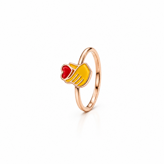 Rose gold ring with a small red and yellow enamel heart-hand charm for newborns priced under Rs. 15,000