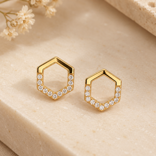 Gold hexagon-outline stud earrings lined with a single row of pave diamonds. Priced under Rs. 30,000