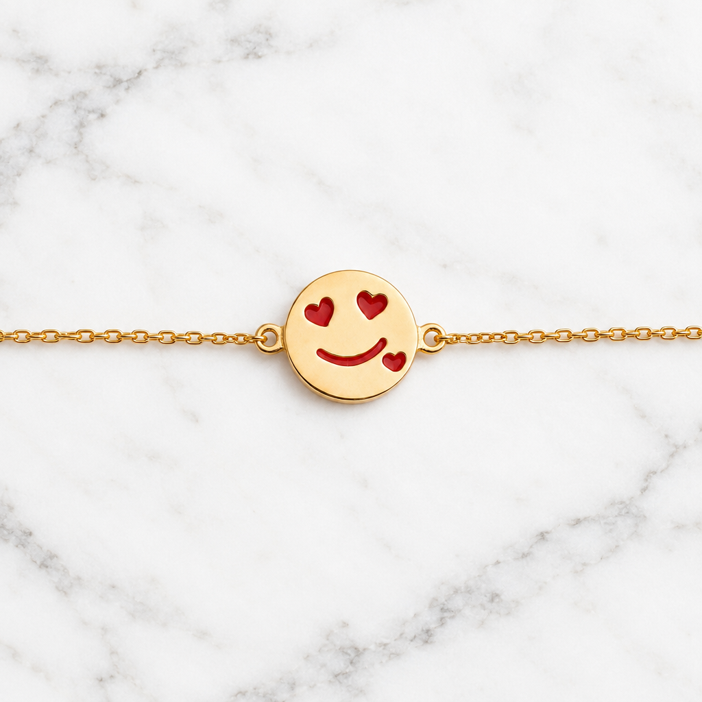 Gold bracelet with a round disc charm featuring a smiley face and red heart eyes. Cute gold gifts for kids under Rs. 40,000