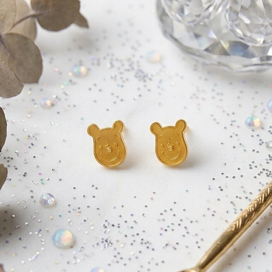 Pair of gold stud earrings shaped like Winnie the Pooh's face. Minimal and cute gifts under Rs. 20,000