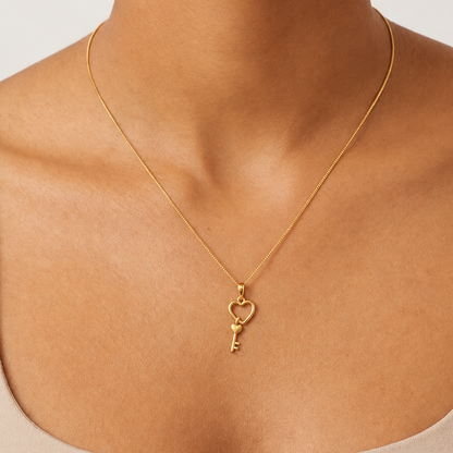 Gold open-heart pendant with a small key charm nestled inside. Minimal and cute gifts for her under Rs. 20,000
