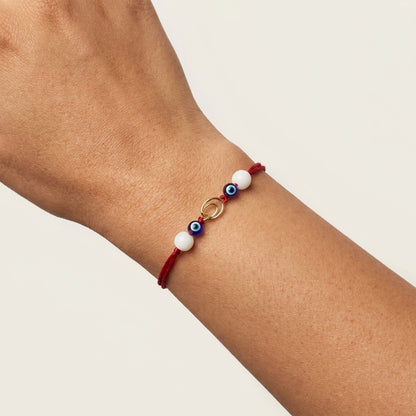 Interlocking gold circle Rakhi with evil eye and pearls.