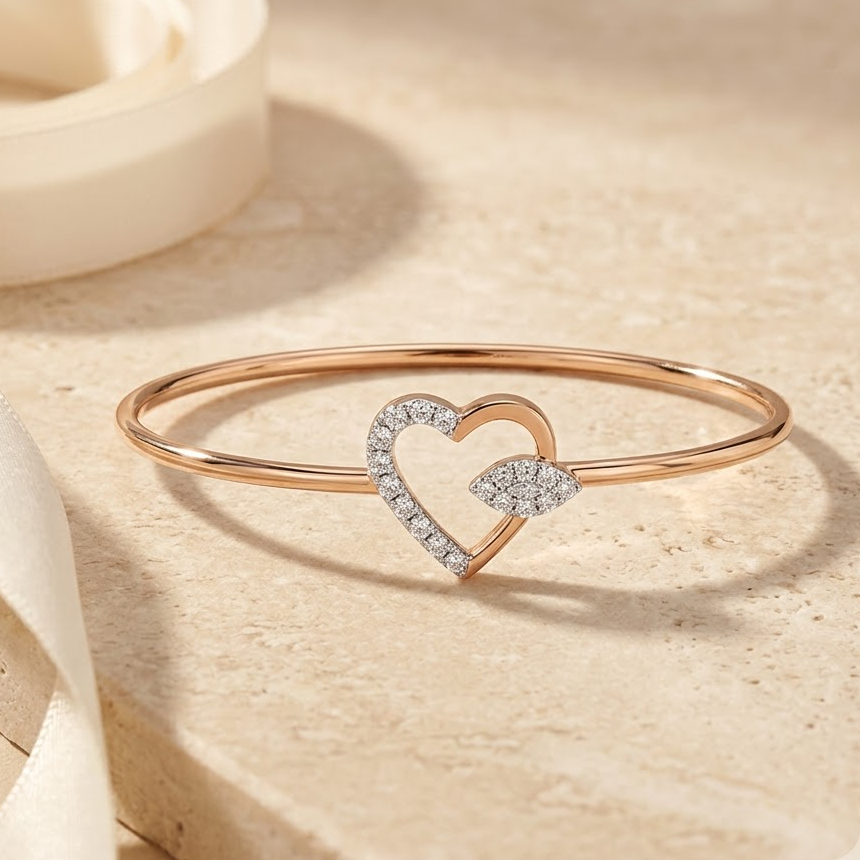 Rose gold bangle-style bracelet with an open diamond heart charm.