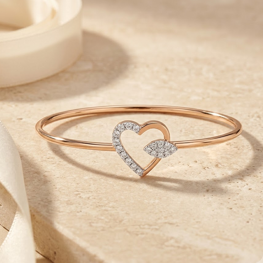 Rose gold bangle-style bracelet with an open diamond heart charm.