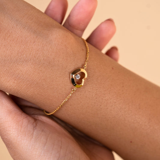 Caratly 18kt gold Love Diamond Bracelet featuring a polished open heart charm with a single bezel-set diamond floating in the center. Perfect minimal gift for her under Rs. 40,000