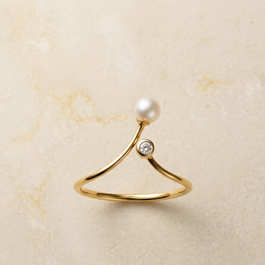 Gold ring with a curved open band, topped with a white pearl and a small diamond under Rs. 20,000