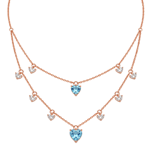 Layered rose gold necklace with clear crystal diamond drops and two blue heart-shaped gemstone pendants priced under Rs. 2,00,000