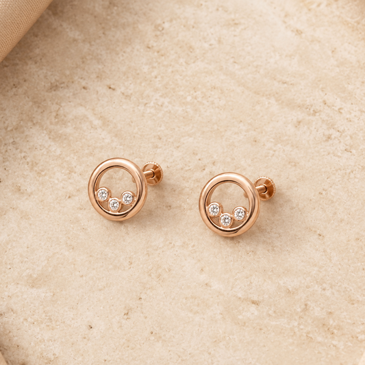 Rose gold circular stud earrings each set with three round diamonds. Priced under Rs. 40,000