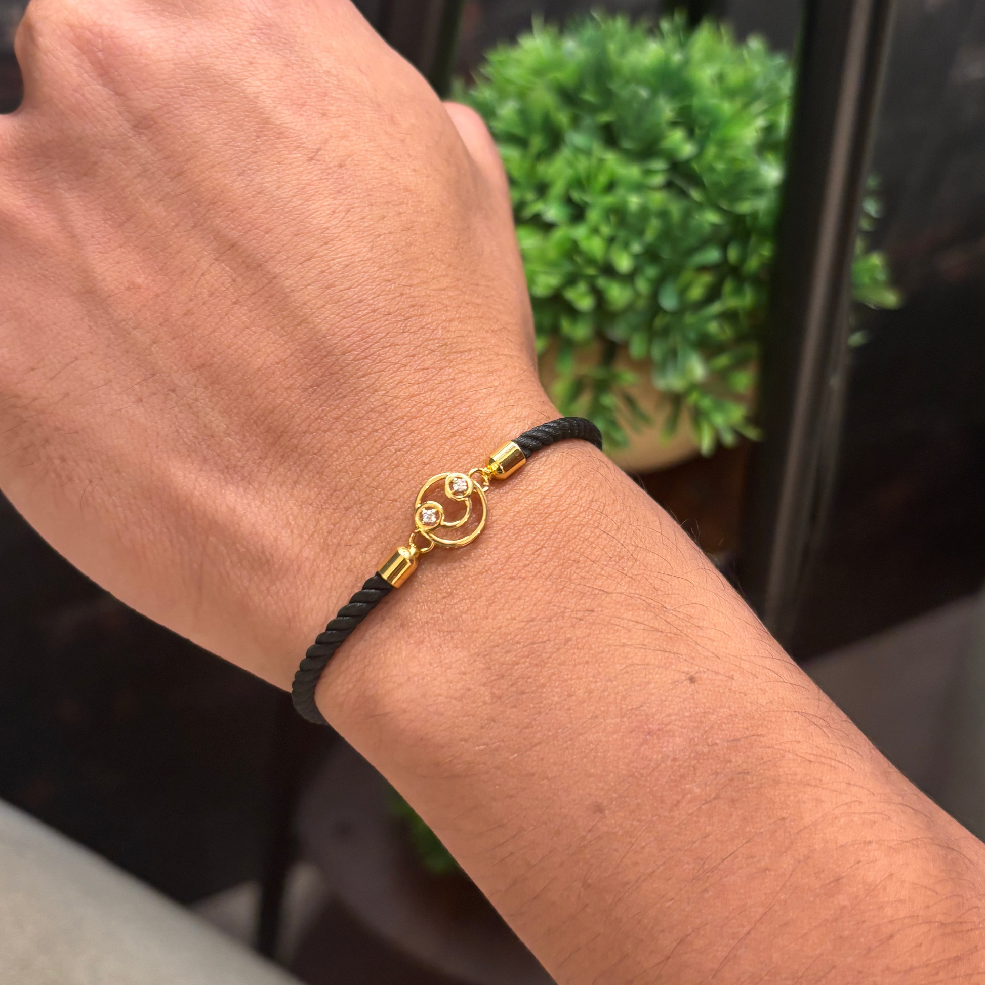 Black rope men's diamond bracelet with an 18kt gold smiley face charm. A perfect gift for him under Rs. 15,000