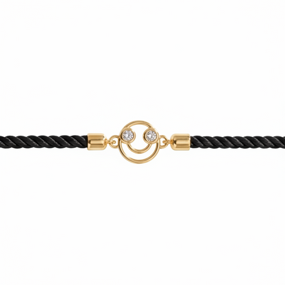 Black rope men's diamond bracelet with an 18kt gold smiley face charm, laid flat on white background. A perfect gift for him under Rs. 15,000