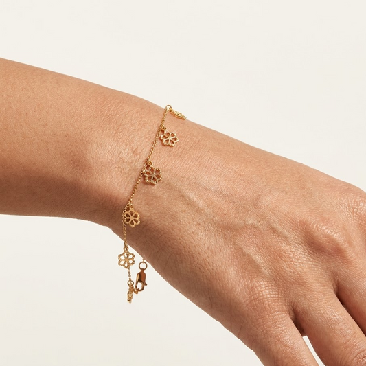 Delicate rose gold vertical chain bracelet with small flower and bead station charms priced under Rs. 35,000