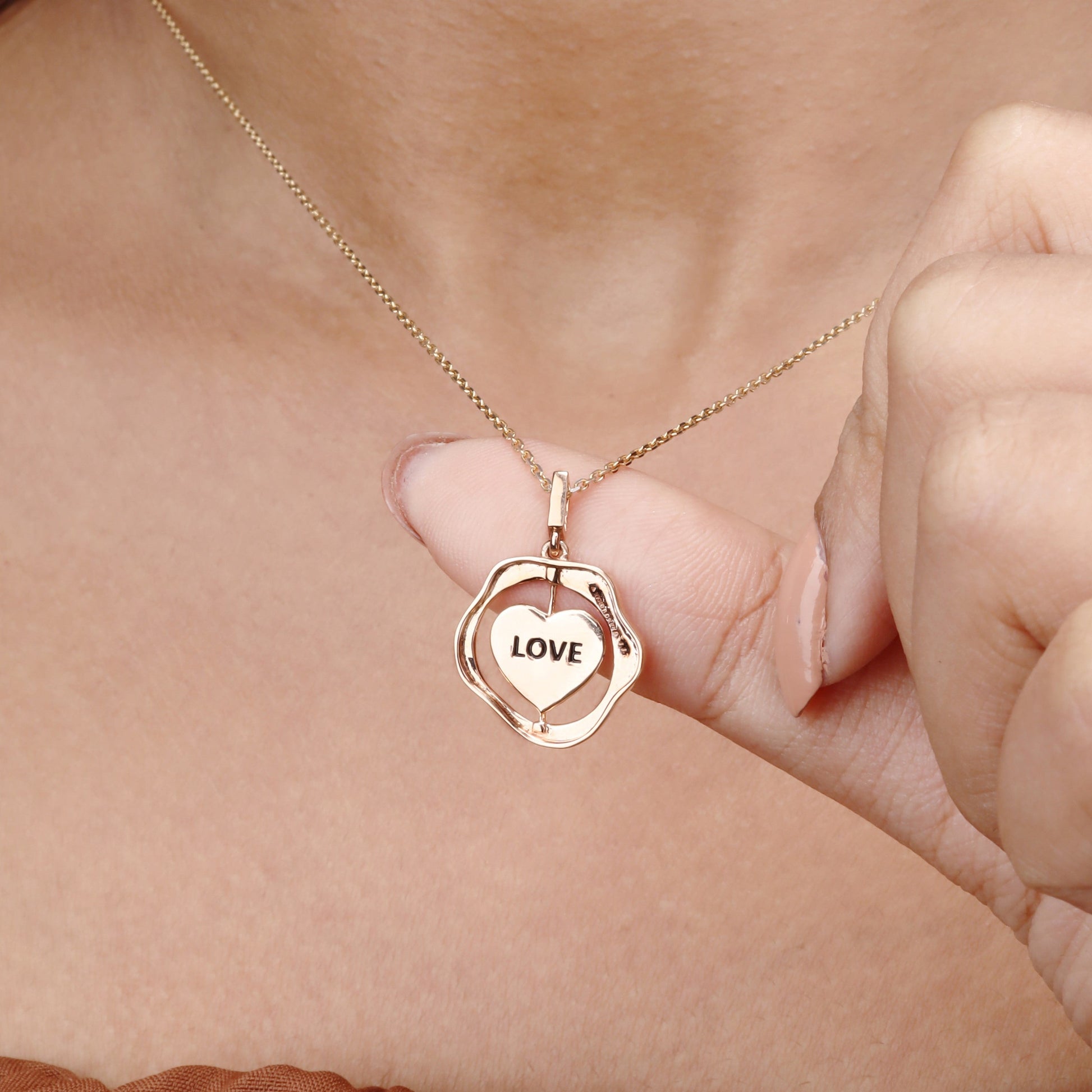 Caratly 18kt gold Love Gold Pendant featuring an organic wavy outer ring and a spinning inner circle engraved with the word LOVE under Rs. 50,000