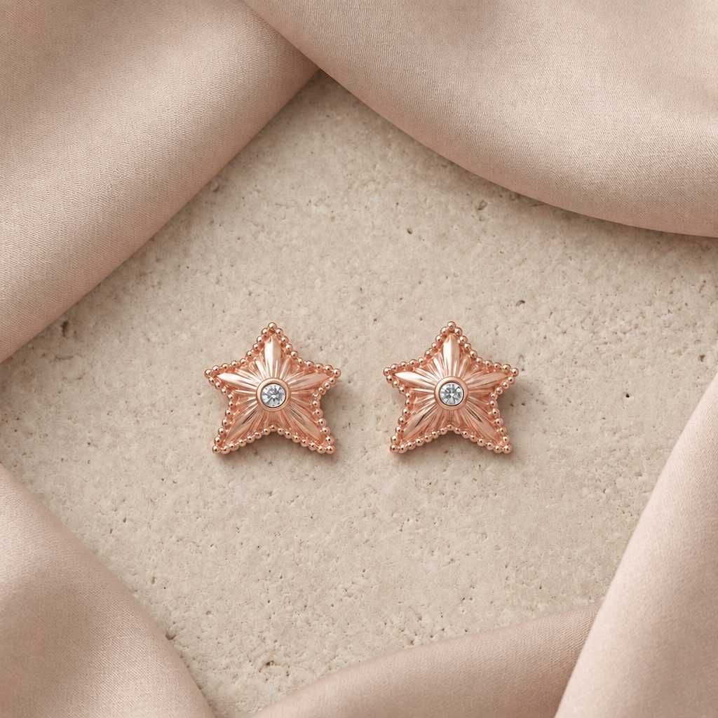 Rose gold textured star stud earrings with a sparkling stone at center. Priced under Rs. 35,000